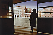 Woman standing at vaporetto station,  Canale Grande, Venice, Italy