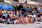 Eine Gruppe junge Leute am Strand, Sa Trincha, Platja de ses Salines, Ibiza, Spanien