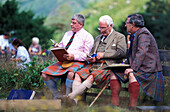 Männer im Schottenrock auf einer Bank, Preisrichter bei den Glenfinnan Highland Games, Glenfinnan, Schottland, Grossbritannien, Europa