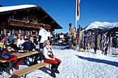 Menschen vor einer Skihütte im Sonnenlicht, Breitfußalm, Hinterglemm, Salzburger Land, Österreich, Europa