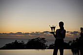Waiter at the pool of Hotel Restaurant Le Rayon Vert in the evening light, Deshaies, Basse-Terre, Guadeloupe, Caribbean Sea, America
