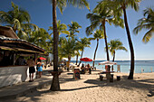 Strandbar und Menschen unter Palmen am Caravelle Beach, Grande-Terre, Guadeloupe, Karibik, Amerika