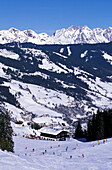 Skiers on slope, ski hut in background, Saalbach-Hinterglemm, Salzburg (state), Austria
