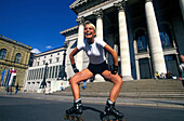 Woman inline skating in front of National Theatre, Munich, Bavaria, Germany