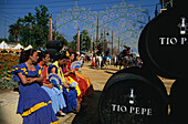Women in traditional costumes and barrels at Feria del Caballo, Jerez de la Frontera, Cadiz, Andalusia, Spain, Europe