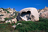 Woman looking to heart shaped rock, Tafoni, Corsica, France