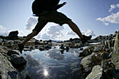 Hiker crossing stream, Dalsnibba, More og Romsdal, Norway