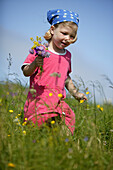 Girl with flower buquet, running in field
