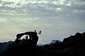 Salto del Pastor Canario, traditionelle Sprung-Technik mit kanarischer Schäfer-Latte, das Wahrzeichen der Insel Roque Nublo im Hintergrund, Gran Canaria, Kanarische Inseln, Spanien