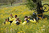 Group of cyclists sitting in meadow, Majorca, Balearic Islands, Spain