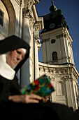 Sister with book in front of church, Ettal Cloister, Bavaria, Germany