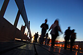 Silhouetten von Menschen auf der Rambla del Mar am Abend, Port Vell, Barcelona, Spanien, Europa