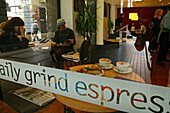 Blick durch ein Fenster auf Menschen in der Daily Grind espresso bar, Christchurch, Südinsel, Neuseeland, Ozeanien