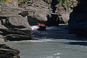 Menschen fahren ein Jetboot auf dem Shotover Fluss, Queenstown, Central Otago, Südinsel, Neuseeland, Ozeanien