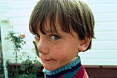 Portrait of pupil Ben with praying mantis on his nose, North Island, New Zealand, Oceania