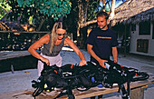 Taucher und Tauchlehrer beim Zusammenbau des Kreislauftauchgerät, Diving teacher checks the rebreather