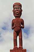 Geschnitzte Tekoteko Figur unter Wolkenhimmel, Rotorua, Nordinsel, Neuseeland, Ozeanien