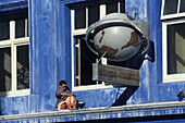 Reading outside coloured facade, Woman reading outside building first floor, lesen am Bunten Gebaudefassade, lifestyle