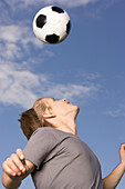 Young soccer player exercising headers