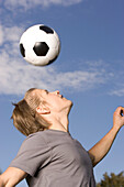 Young soccer player exercising headers