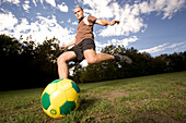 Young soccer player kicking the ball