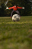 Young goalkeeper awaiting penalty, arms outstretched
