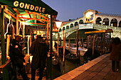 Drei Gondelführer vor einem Gondel Mietservice neben der Rialto Brücke, Canale Grande, Venedig, Italien