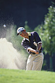 Golfspieler beim Schlag aus dem Sandbunker