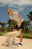 Eine Frau steht im Bunker, spielt Golf, Mauritius
