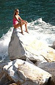 Frau sitzt auf einem Fels und meditiert, Meditation, Cinque Terre, Italien