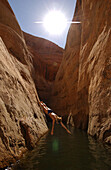 Eine Person beim Klippenspringen, Secret Canyon, Lake Powell, Utah, Arizona, USA