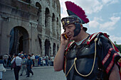 Legionnaire with mobile phone in front of the Colosseum, Rome, Latium, Italy, Europe