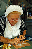 Lacemaker wearing traditional costumes, Bruges, Flanders, Belgium, Europe