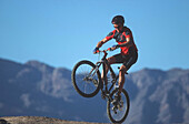 Mountainbiker in front of Anti-Atlas mountains, Tafraout, Morocco, Africa