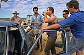 Visitors Birdsville horse race, Queensland, Birdsville, on the way to the annual outback horse race, men drink and repair a tyre, Besucher fahren zum Pferderennen.