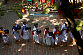 line of young nuns going into the dining hall of monastery, Myanmar