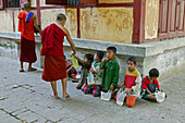 Mahagandaryone Monastery, Children line up for rice from monks in the monastery grounds, Essenausgabe fuer arme Kinder im Kloster, Amarapura bei Mandalay