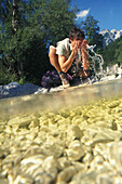 Hiker refreshing himself at a river