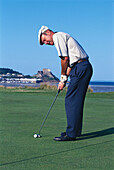Man playing golf, Orgeuil castle in the background, Jersey, Channel islands, Great Britain, Europe