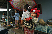 village women, woman carrying child on back, Ban Phan Tang, Laos