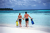 Young couple with flippers in the water, Four Seasons Resort, Kuda Hurra, Maledives, Indian Ocean