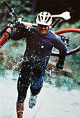 Mountainbike, Mann traegt Rad durchs Wasser