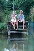 Junge und Mädchen fischen am See