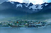 Town in the fog in front of snow covered mountains, Ushuaia, Argentina, South America, America