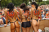 Three go-go dancers at the Loveparade, devil tattoo on their backs, Berlin, Germany
