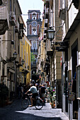 Bicyclist crossing alley in Sorrento, Campania, Italy