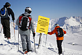 Three skier passing warning sign, leaving safety slope, Nebelhorn, Oberstdorf, Bavaria