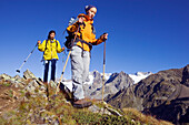 Zwei junge Frauen wandern in den veltliner Alpen, im Hintergrund das Bernina Palü Massiv, Veltlin, Italien