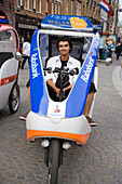 Man, Bicycle Taxi, Damrak, Smiling man sitting in moped taxi, Damrak, Amsterdam, Holland, Netherlands