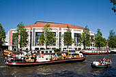 Boats, Amstel, Stopera Theater, , People in boat on amstel passing Stopera, the muziektheater of Amsterdam, Amsterdam, Holland, Netherlands